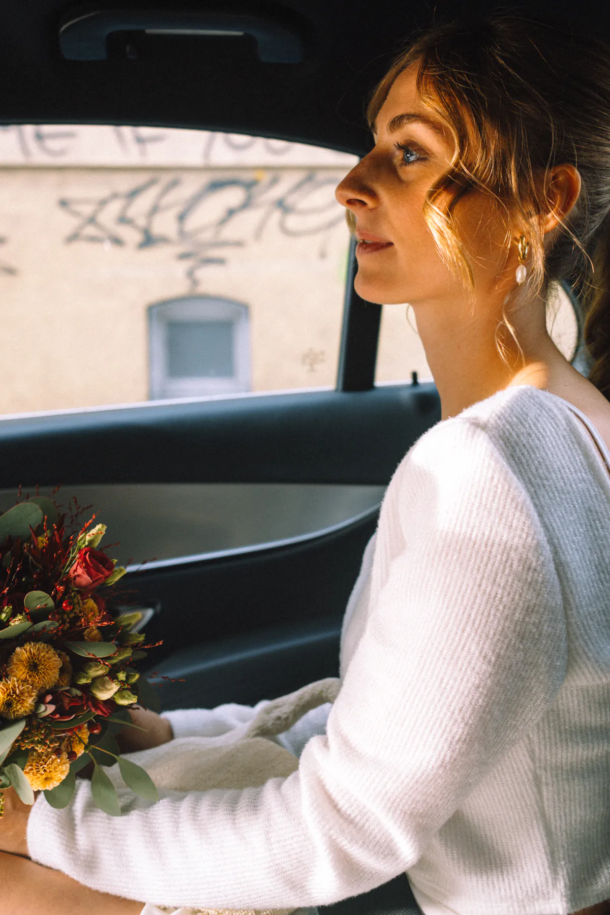 Braut mit Blumenstrauß im Auto, Blick aus dem Fenster